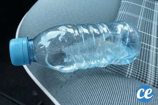 bouteille en plastique posée sur un siège de voiture gris