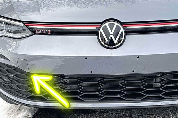 Une flèche jaune fluo sur le cache pare-choc devant d'une Volkswagen GTI grise