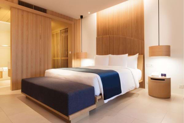 Une chambre d'hôtel avec une petite couverture bleue sur le bout du lit