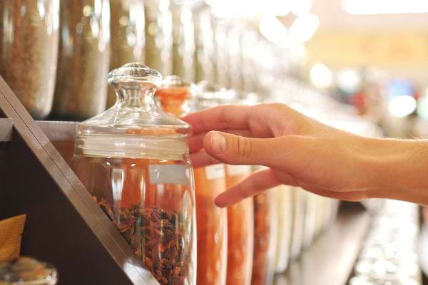 Une personne qui a l'air de prendre un bocal rempli de condiment 