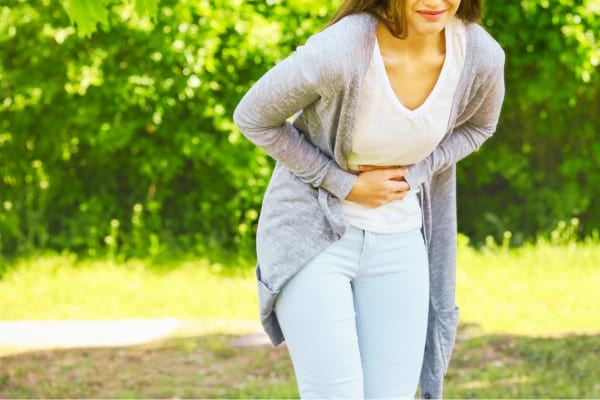Une femme qui se tord le ventre à cause de flatulences excessives