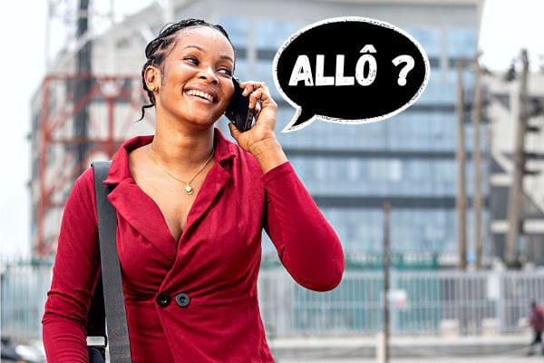 Une femme noire avec une robe de couleur bordeaux au téléphone avec un icône qui dit "Allô"