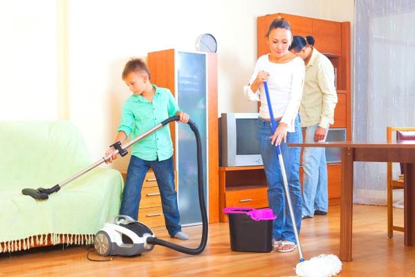 Une famille fait le ménage dans le salon
