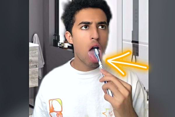 Un homme se brossant la langue avec une brosse à dents 