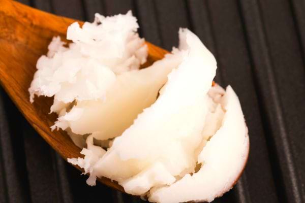 huile de coco sur une cuillère en bois