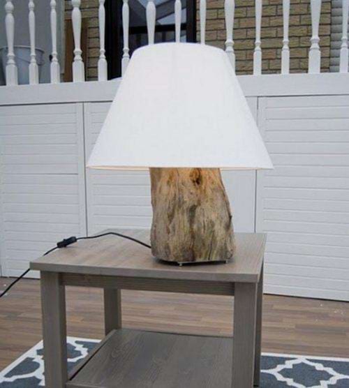 Un tronc d'arbre transformé en lampe sur une petite table 