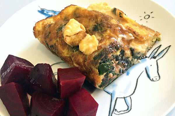 Une omelette aux fanes de betterave dans une assiette blanche avec un âne décoré