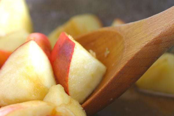 des morceaux de pommes avec une cuillère en bois