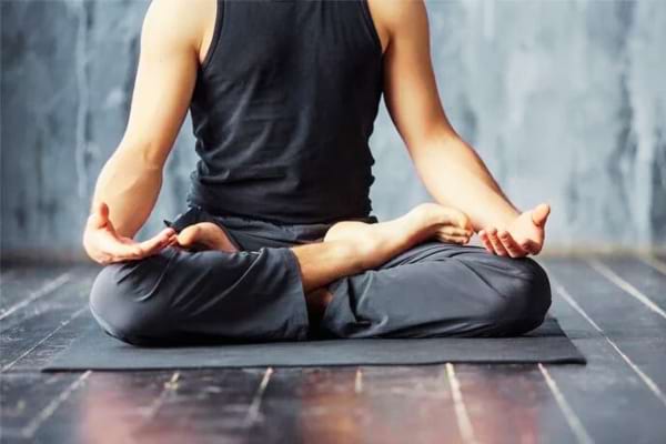 Un homme en posture de méditation pour gérer le stress et l'impact sur la langue fissurée