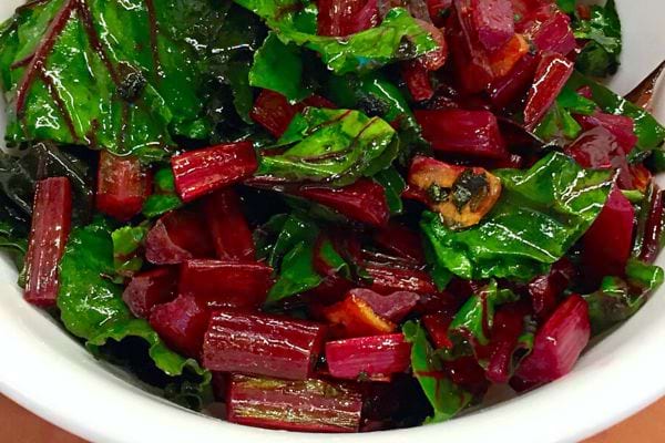 Une salade de fanes de betterave dans un récipient blanc