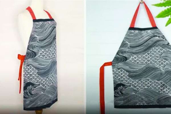 Un tablier décoré avec des vagues et des rubans rouges sur un mannequin 