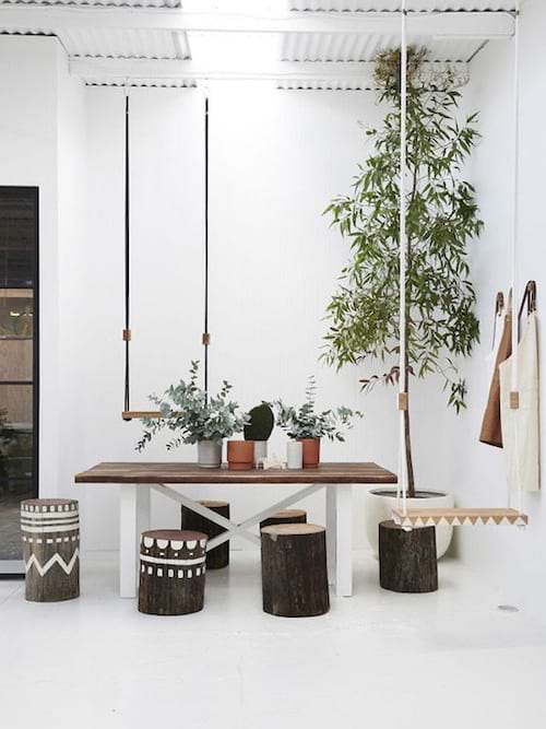 Un tronc d'arbre transformé en plusieurs tabourets devant une table 