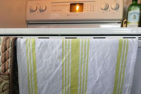 Un torchon blanc et jaune accroché à un four 