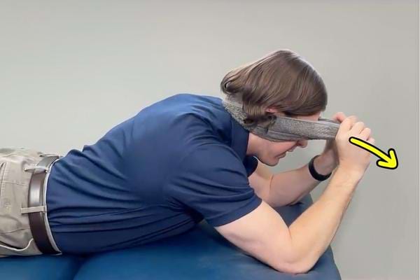 Une traction cervicale avec une serviette pour soulager les migraines.