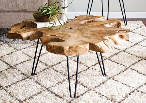 Un tronc d'arbre transformé en table basse sur un tapis 