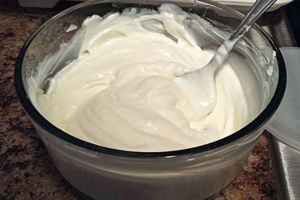 Du yaourt dans un grand bol en verre avec une cuillère à l'intérieur 