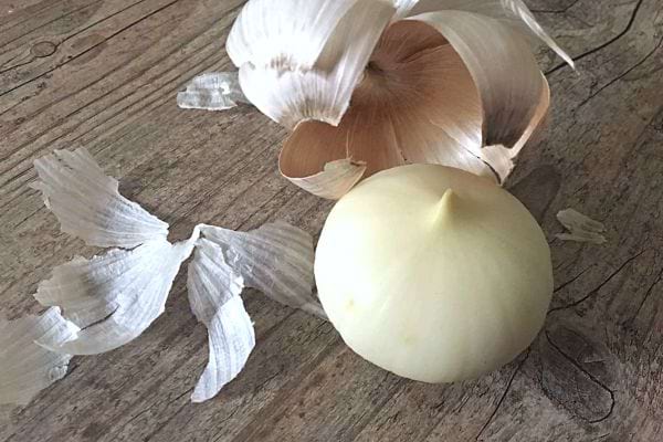 Un ail épluché entièrement sur une table en bois 