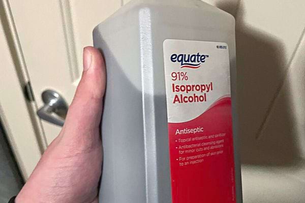 Eine Person hält eine Flasche Isopropylalkohol