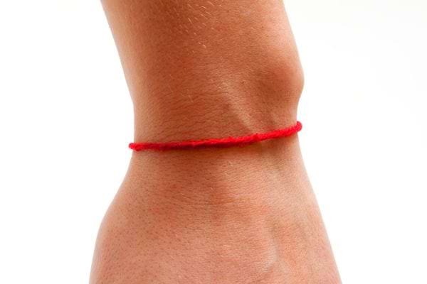 Une personne ayant un bracelet rouge fin à son poignet
