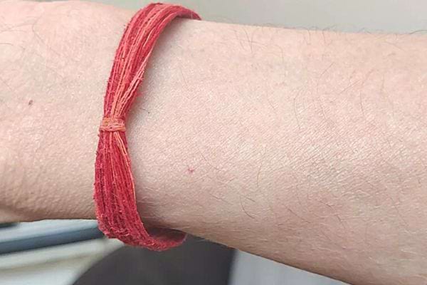Une personne ayant un bracelet rouge épais à son poignet