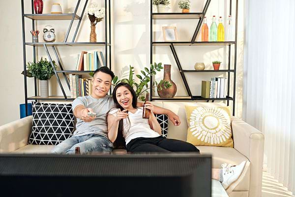 Un jeune couple asiatique devant une télé 