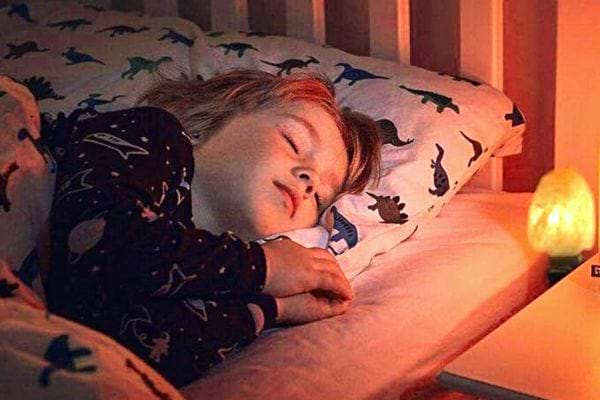 Un enfant qui dort proche d'une lampe de sel