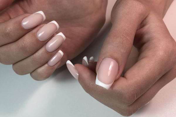 Une personne ayant une french sur ses ongles de doigts 