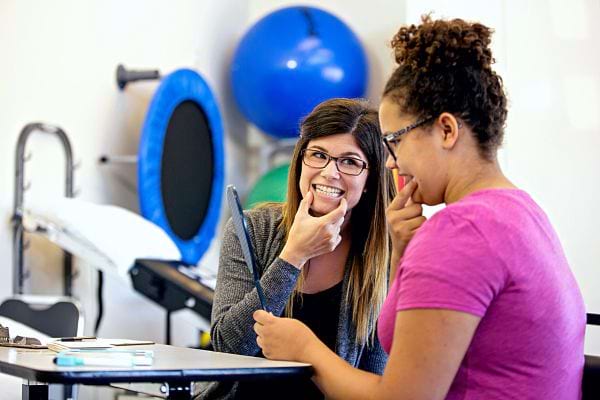 Une femme blanche à proximité d'une femme métisse se tenant la bouche