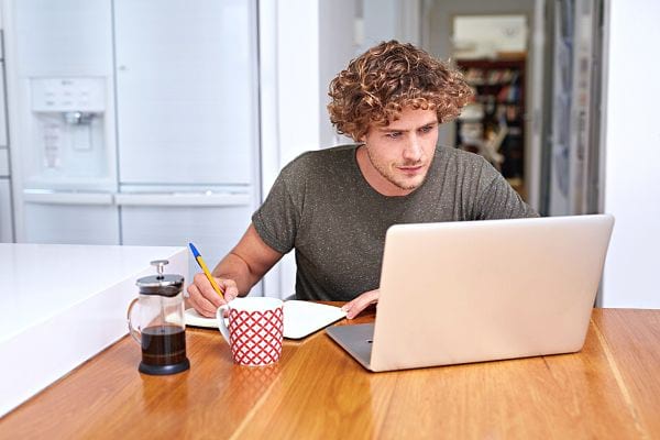 Un homme qui écrit devant son ordinateur 