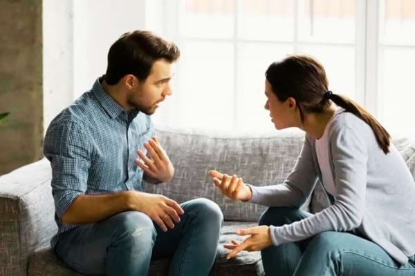 Un homme sur la défensive qui parle à sa femme