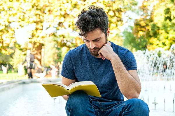 Un homme qui lit avec une couverture jaune 