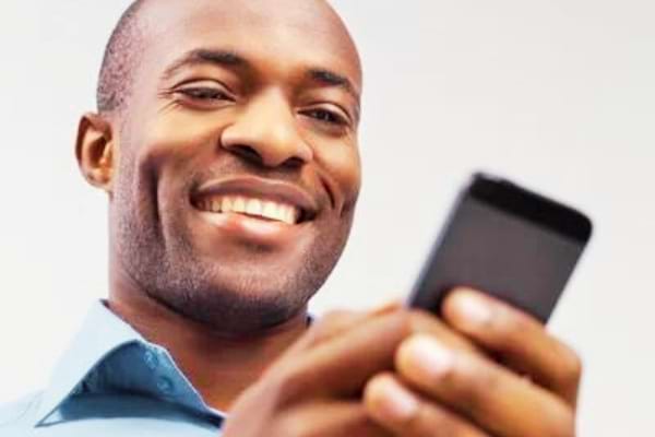 Homme qui sourit quand il reçoit un message d'une autre femme