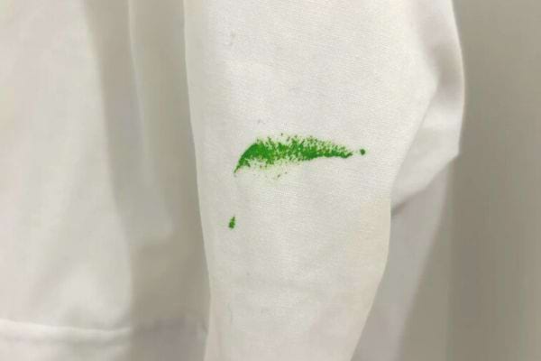 Ein grüner Farbfleck auf einem weißen Kleidungsstück