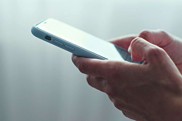 Une personne tenant son téléphone à deux mains