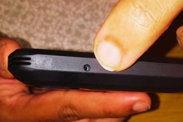 Un petit trou en bas d'un téléphone portable qui sert de microphone