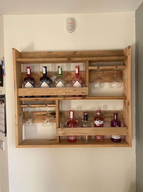 Une palette en bois accrochée au mur comme rangement à bouteiles