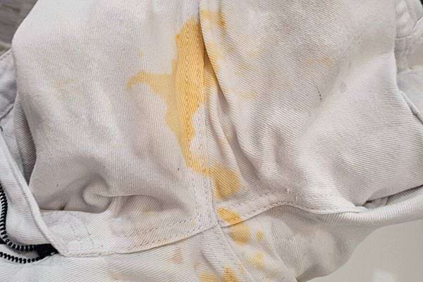 Orangefarbene Flecken auf weißer Kleidung