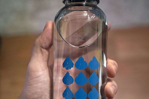 Une personne tenant une gourde remplie d'eau