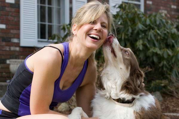 Un chien qui lèche le visage d'une femme blonde