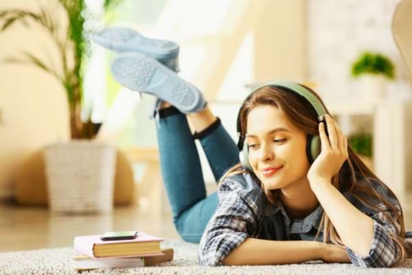 Une femme allongée qui écoute un livre audio gratuit