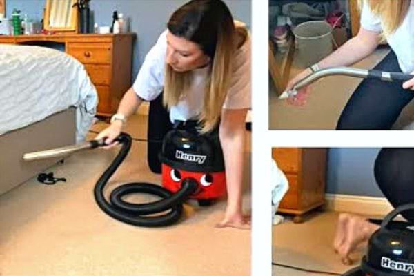 Une femme passant l'aspirateur sur un lit