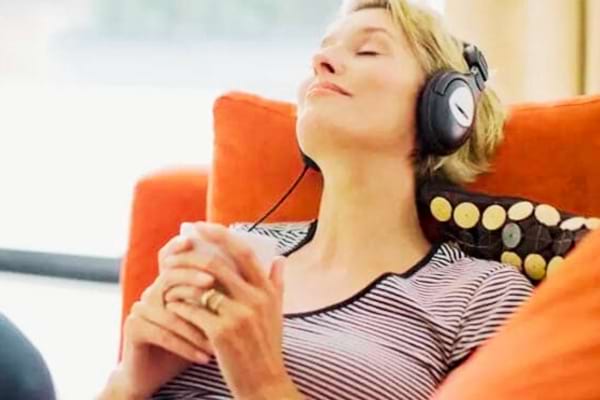 Une femme assise qui écoute un livre audio gratuit