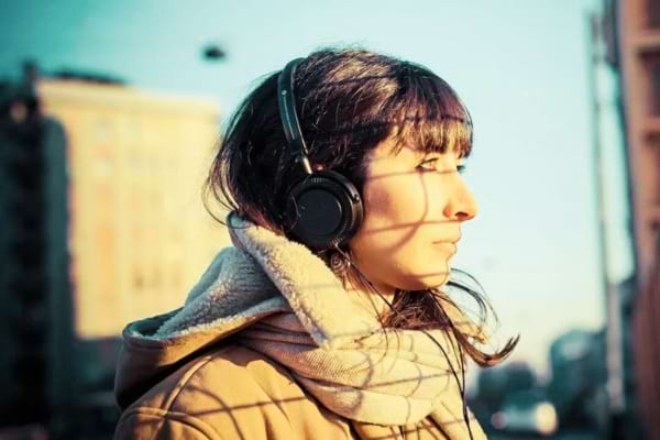 Une femme avec un casque audio qui écoute un livre audio gratuit
