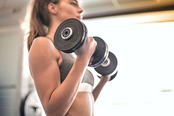 Une femme qui tient des haltères