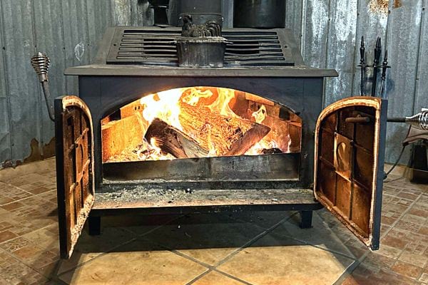 Un feu de cheminée avec les portes de l'insert qui sont ouvertes