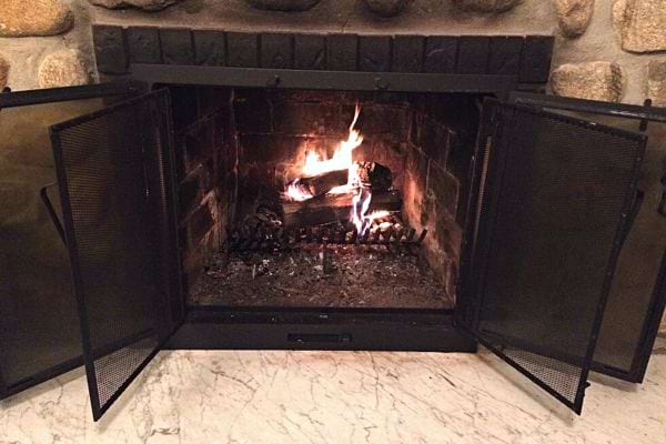 Un feu de cheminée avec les portes de l'insert qui sont ouvertes