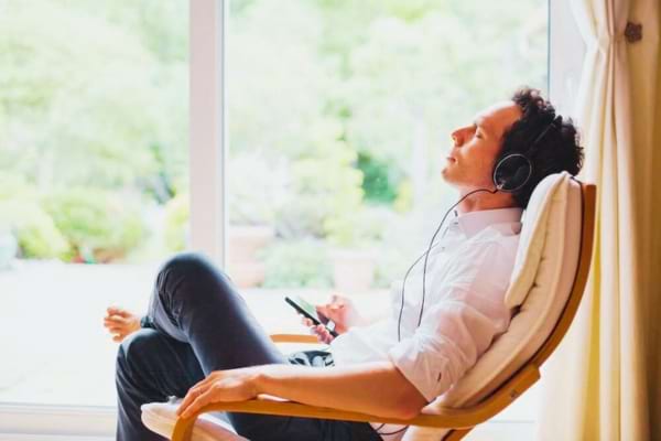 Un homme assis qui écoute un livre audio gratuit