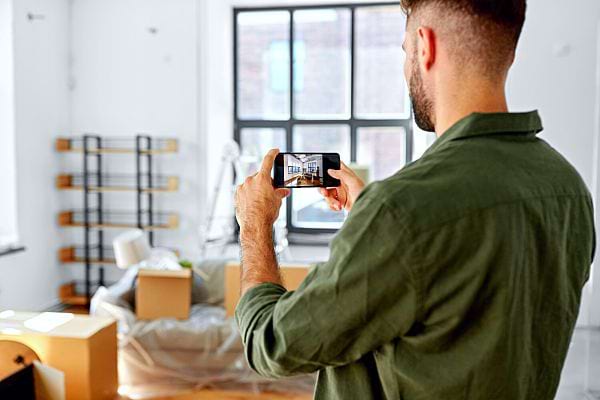 Un homme prenant une photo de l'intérieur de sa maison 