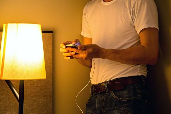 Un homme utilisant son téléphone pendant qu'il charge