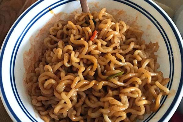 Un bol blanc rempli de nouilles épicées